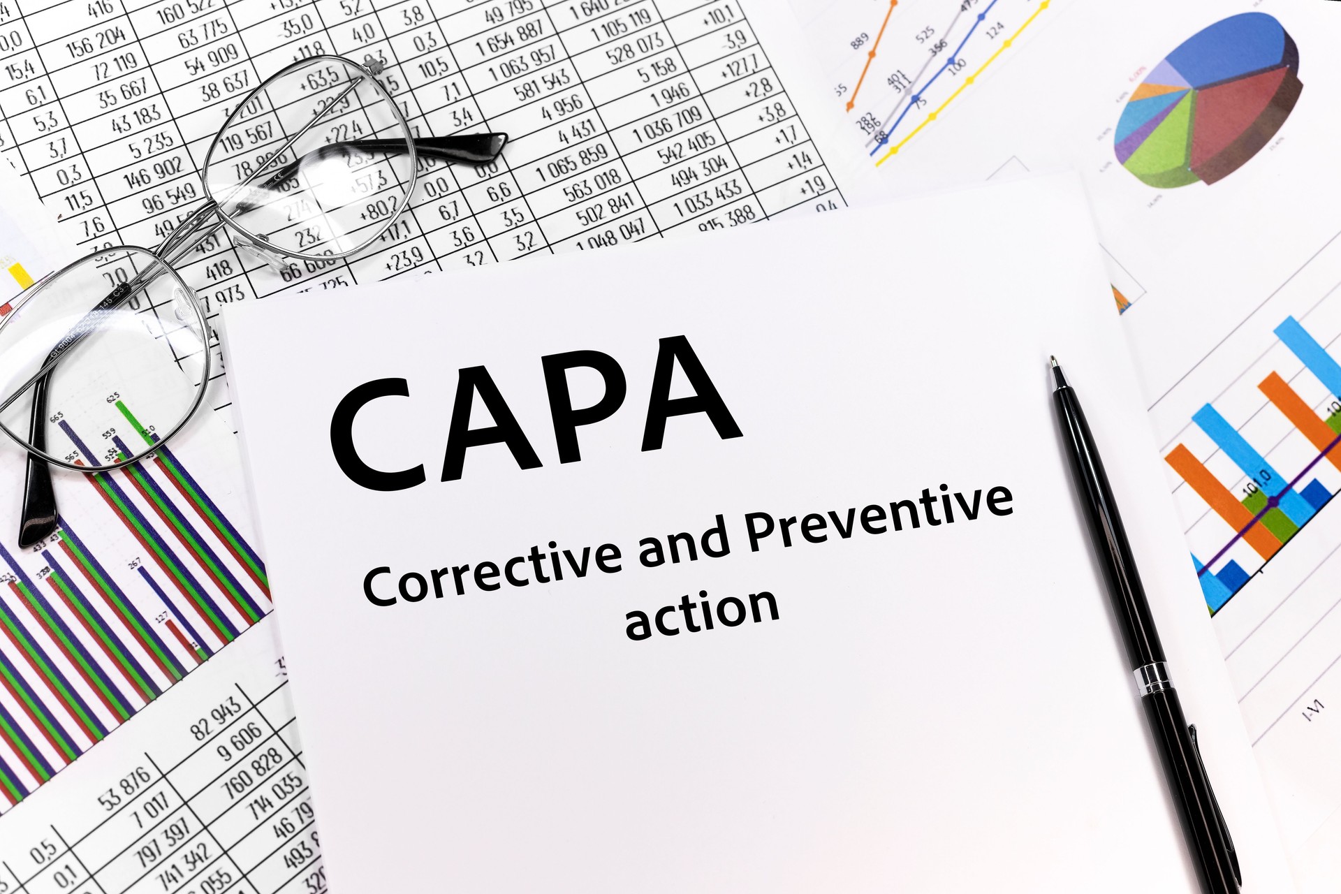 Text CAPA. Concept image of Business Acronym CAPA Corrective and Preventive action written on the sheet. pen, glasses, documents, graphics. Business concept.